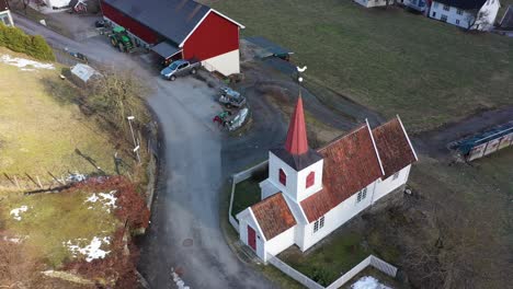 Europes-smallest-Stave-church-in-Undredal-Norway---Beautiful-aerial-rotating-and-descending-around-church-during-morning-sunrise