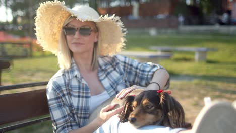 young woman relaxing on bench with her dog