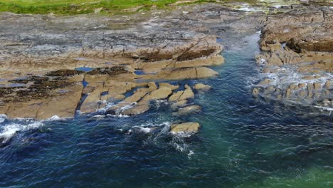 imágenes fijas de drones de olas rompiendo en la costa rocosa