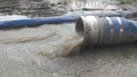 Regenwasser-Wird-Durch-Einen-Blauen-Vinylschlauch-Gepumpt-Und-Auf-Den-Boden-Abgeleitet