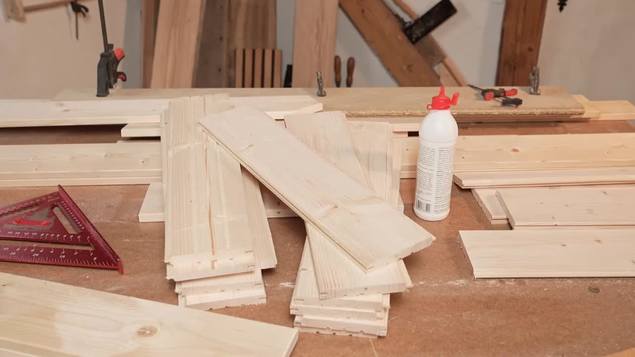 Carpentry workbench with cut pine boards, wood glue, and measuring tools in a workshop. Ideal for DIY, construction, or woodworking themes