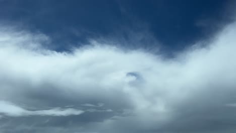 El-Punto-De-Vista-De-Un-Piloto:-Volando-A-Través-De-Algunas-Nubes-Esponjosas-Con-Un-Cielo-Azul-Profundo-En-La-Parte-Posterior