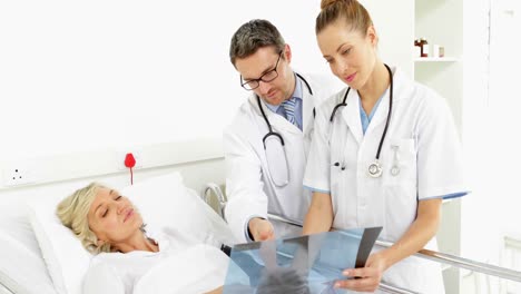 Doctors-explaining-xray-to-sick-patient-in-bed