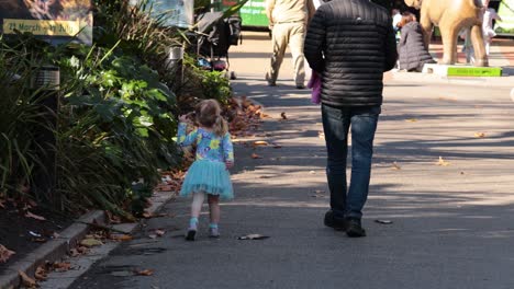 a father and daughter walking together at the zoo