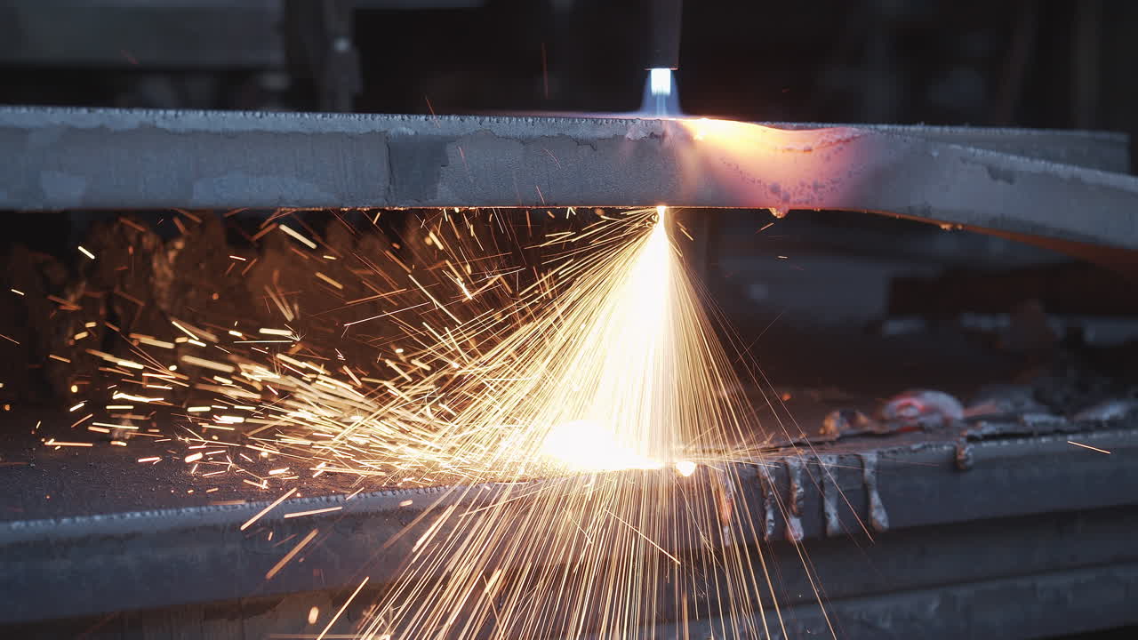 Plasma cutter cuts metal in an industrial company - High energy through heat and electrical power - Special tools in the metal industry - Sparks and fire in high resolution 4K shot - Close up