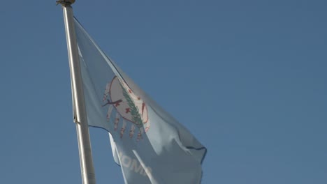 Oklahoma-State-Flag-blowing-in-the-wind-breeze-against-a-blue-sky-slowly