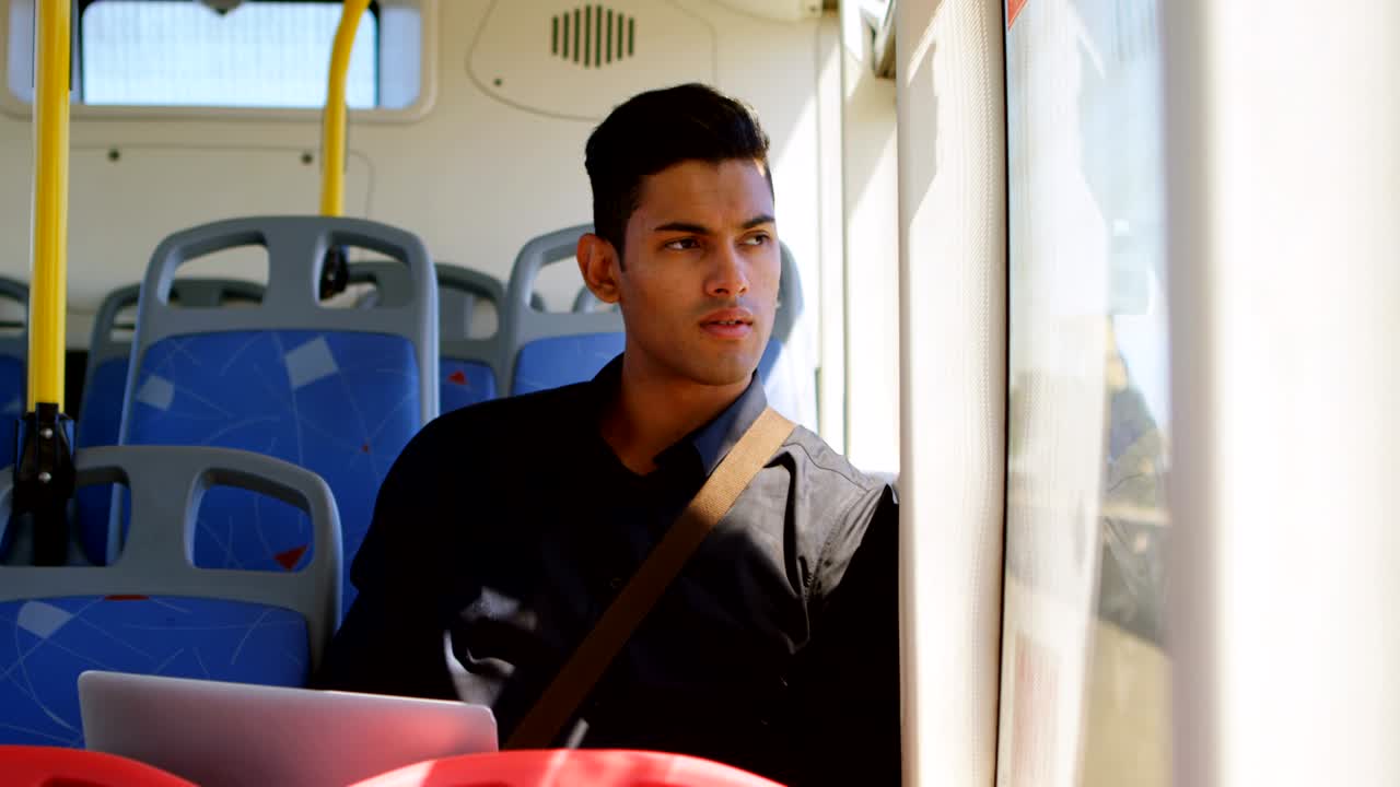 pasajero masculino que usa una computadora portátil mientras viaja en el autobús 4k