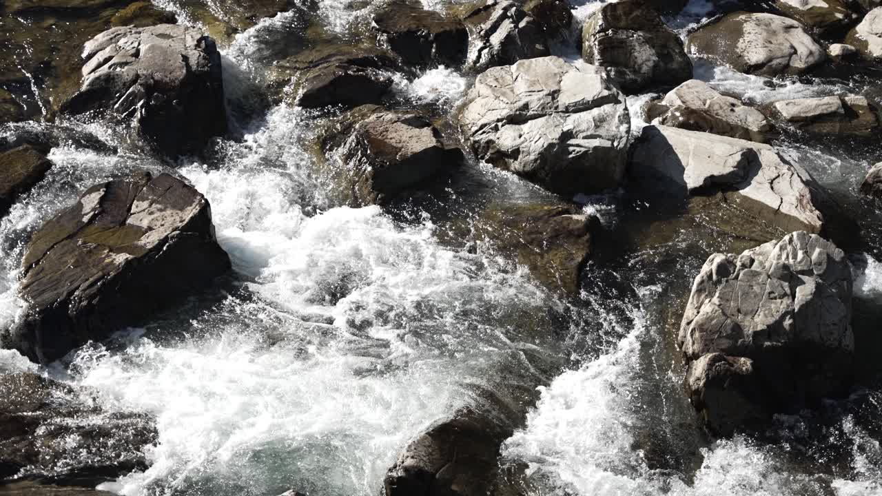 Acqua bianca che scorre rapidamente sulle rocce nella natura selvaggia. Rallentatore.