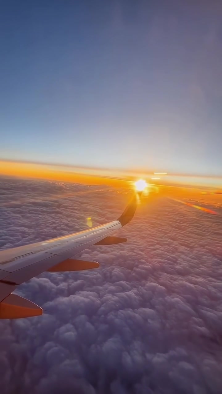 Flyvevinge der flyver over skyer under solnedgang