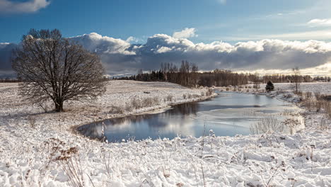 Amazing-time-lapse-of-frozen-land-with-lake-in-winter,-dramatic-cloudscape---establishing-shot