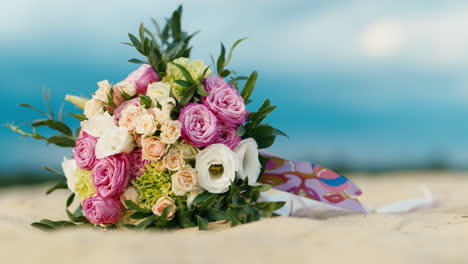 wedding bouquet lies on the sand