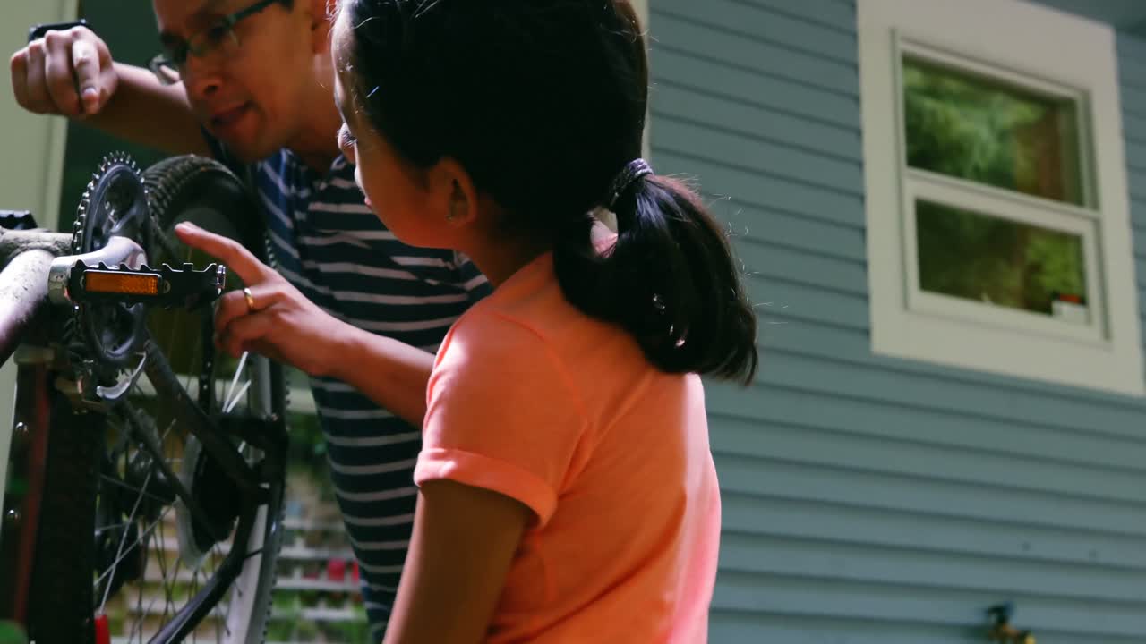 padre e hija reparando bicicletas 4k