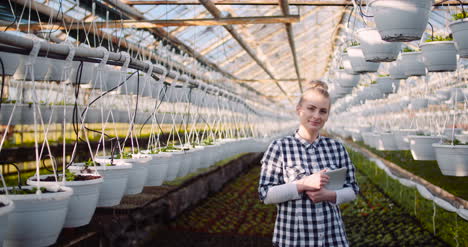 gardener using digital tablet at greenhouse and smile 3