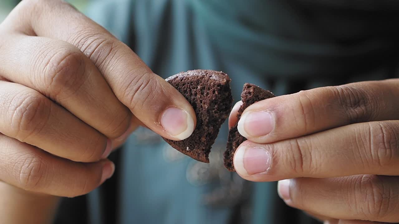 persona comiendo una galleta de chispas de chocolate