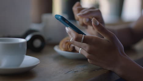 Manos-De-Una-Mujer-Joven-Usando-Un-Teléfono-Inteligente-En-Una-Cafetería-Navegando-Por-Mensajes-En-Línea-Enviando-Mensajes-De-Texto-Compartiendo-Su-Estilo-De-Vida-En-Las-Redes-Sociales-Disfrutando-De-La-Tecnología-De-Telefonía-Móvil-De-Cerca