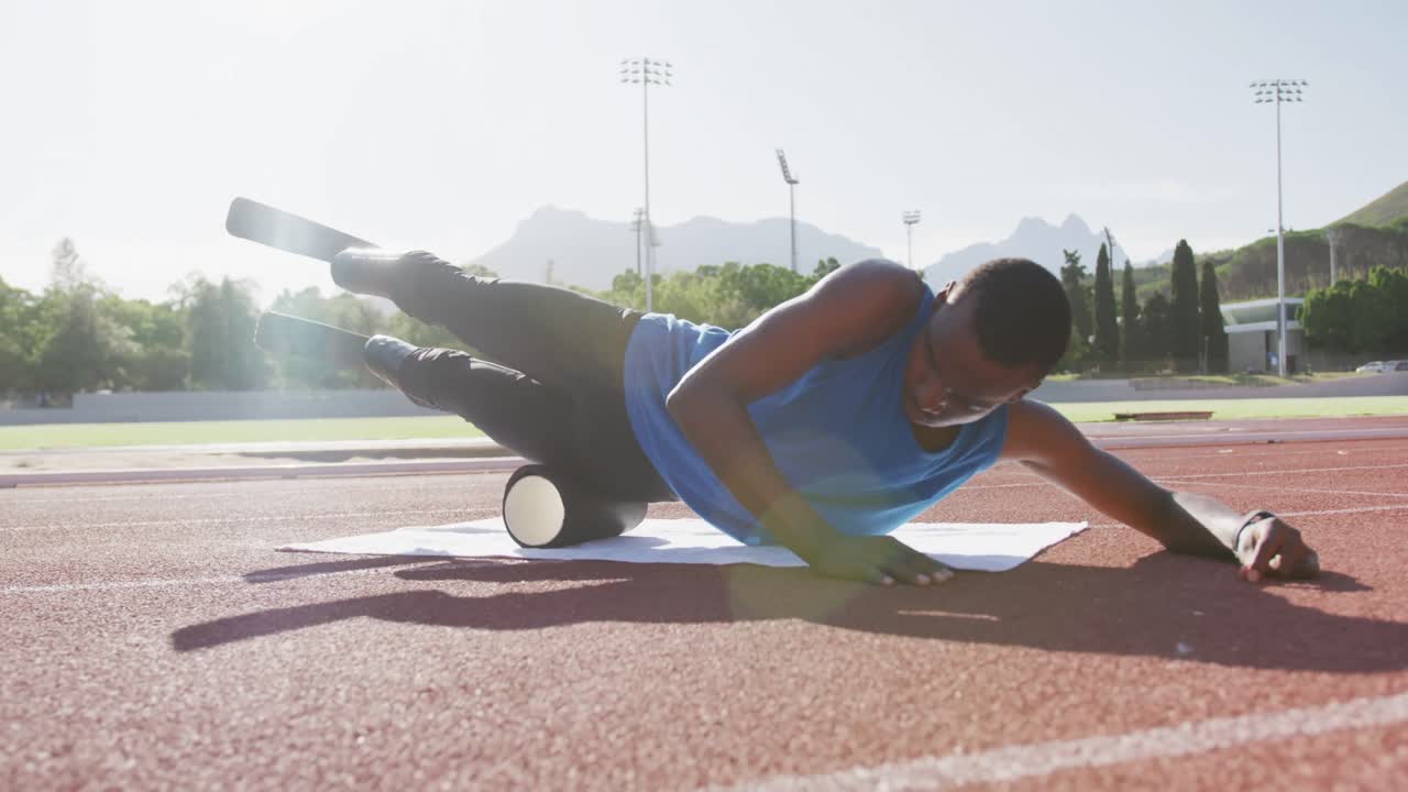 Disabled mixed race man with prosthetic legs stretching with roller