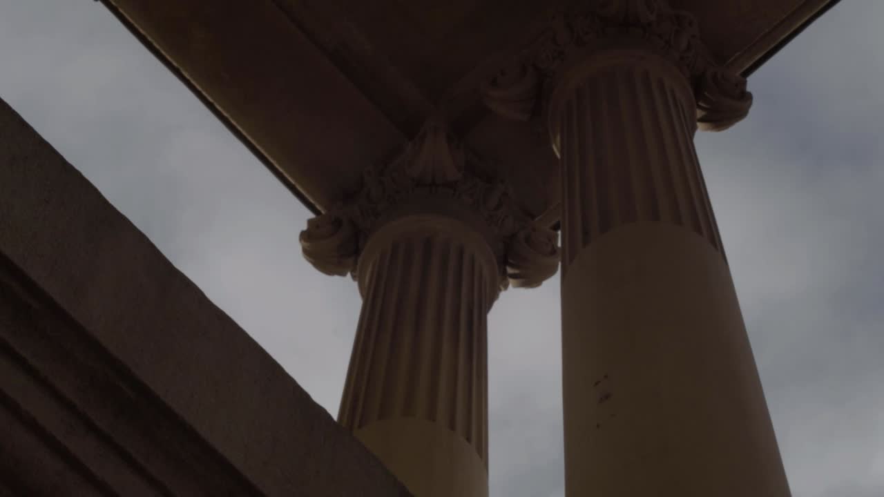 Building with ornate stone pillars and roof against blue skies tilting