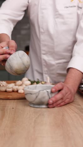 chef using a mortar and pestle to grind spices