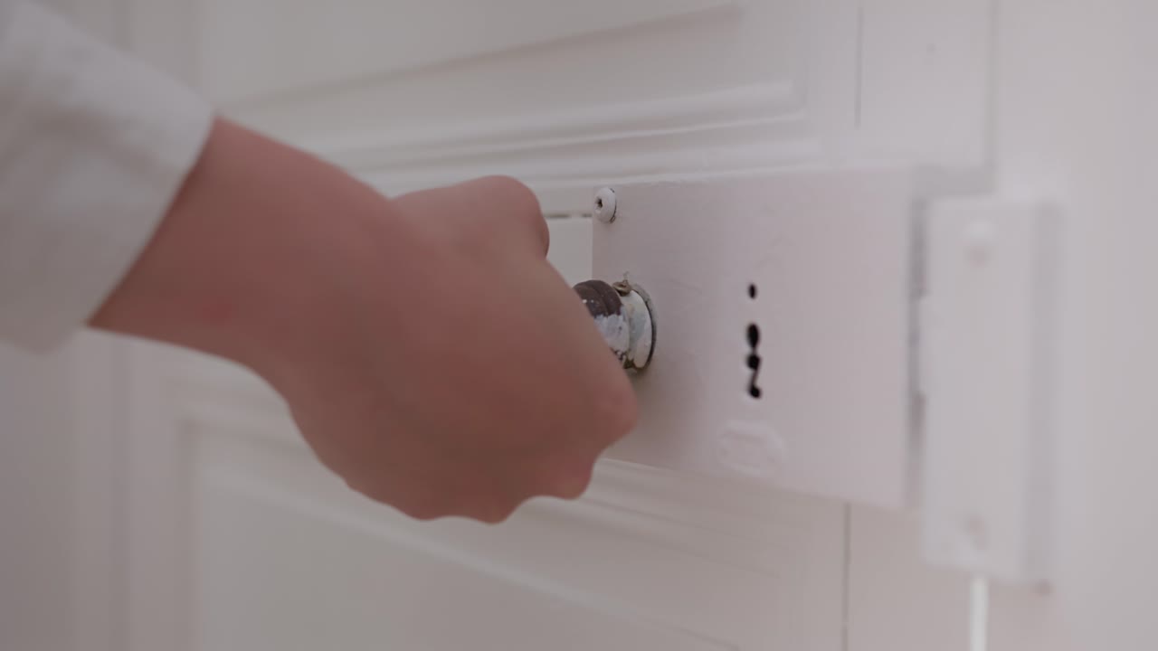 Woman's hand trying to open a locked door