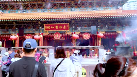 visitors engage in prayer and incense offerings