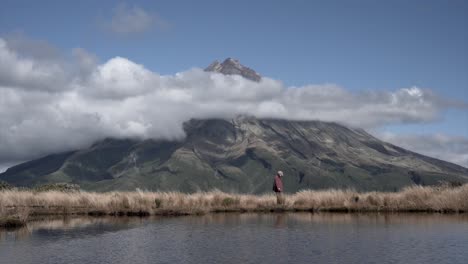 Person walking by a lake with a mountain view