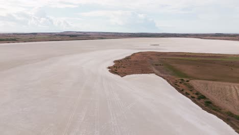 aerial view of a vast saltwater lagoon in sardinia, italy. surrounded by wild nature, this serene wetland is a haven for birdwatching and natural beauty, ideal for nature footage.