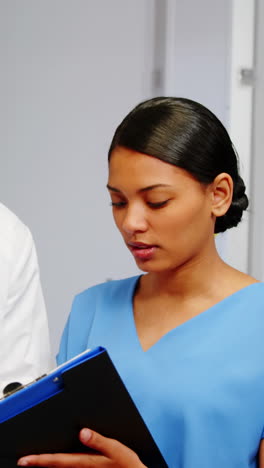 nurse and doctor discussing over clipboard