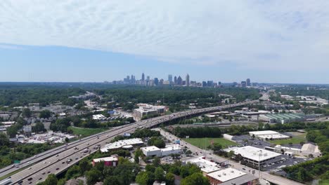 drone shot pulling out from over the atlanta skyline and highway on a summer day