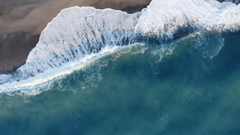 aerial view of ocean waves crashing on a beach