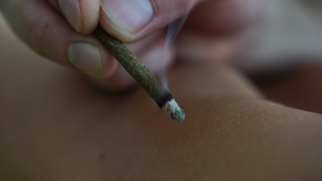 terapeuta que realiza un procedimiento de moxibustion en un centro de salud. la moxibusción es un efecto térmico en puntos biológicamente activos ubicados en toda la superficie del cuerpo humano