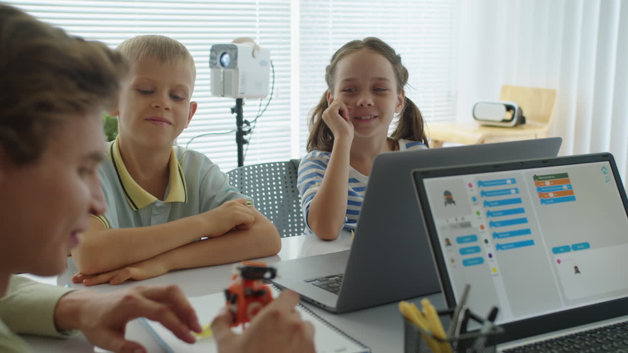 Teacher Explaining Topic to Children at Robot Engineering Class