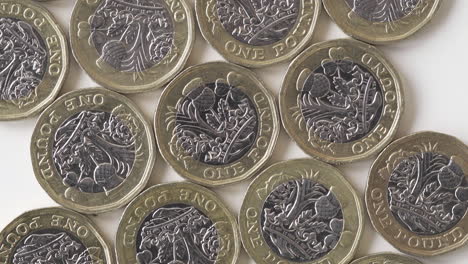 flat lay of british one pound coins on white background - closeup shot vertical