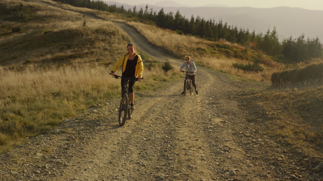 Woman and man riding on bike uphill