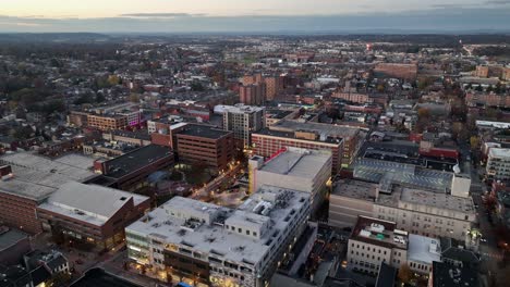 historic american town during golden hour. ancient buildings and festive decorated street during christmas time. office buildings and housing area. rising drone top down.