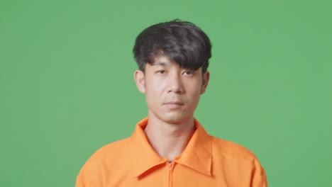 close up of asian male prisoner in handcuffs walking on the green screen background