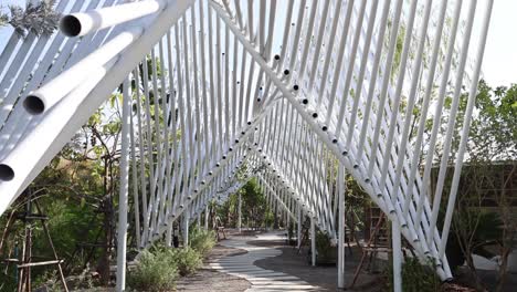 persona caminando a través de una estructura geométrica al aire libre