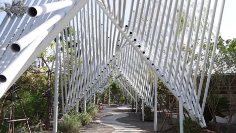 person walking through a geometric outdoor structure