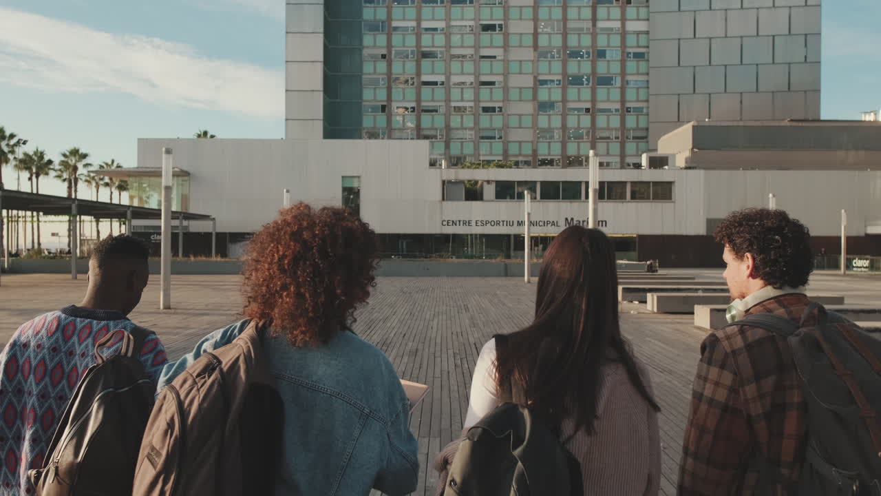 Pessoas com mochilas se aproximando de um prédio