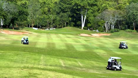 golf carts moving across lush green course