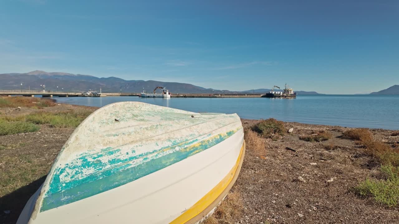 Neglected Greek upturned fishing boat hull derelict on grassy beach