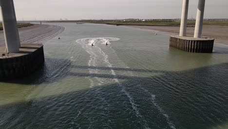 view of jet ski speed racing under sheppey crossing at sunny day in kent, united kingdom