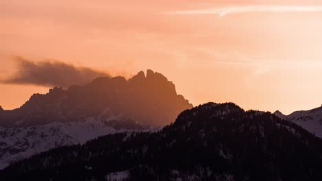the setting sun engulfing the putia mountain in the warm orange glow, ethereal clouds and foglets swirling over the mountain top