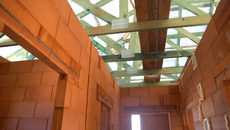 interior view of unfinished brick walls and exposed impregnated roof trusses in daylight