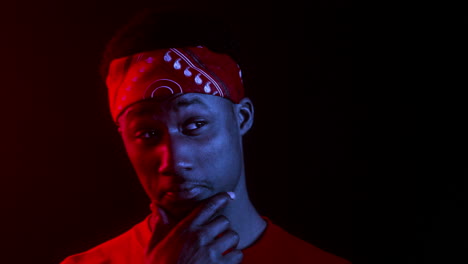 young man with bandana in red and blue light