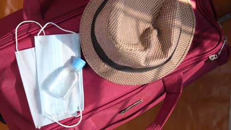 lo esencial para viajar con máscaras faciales y desinfectante de manos en una maleta.