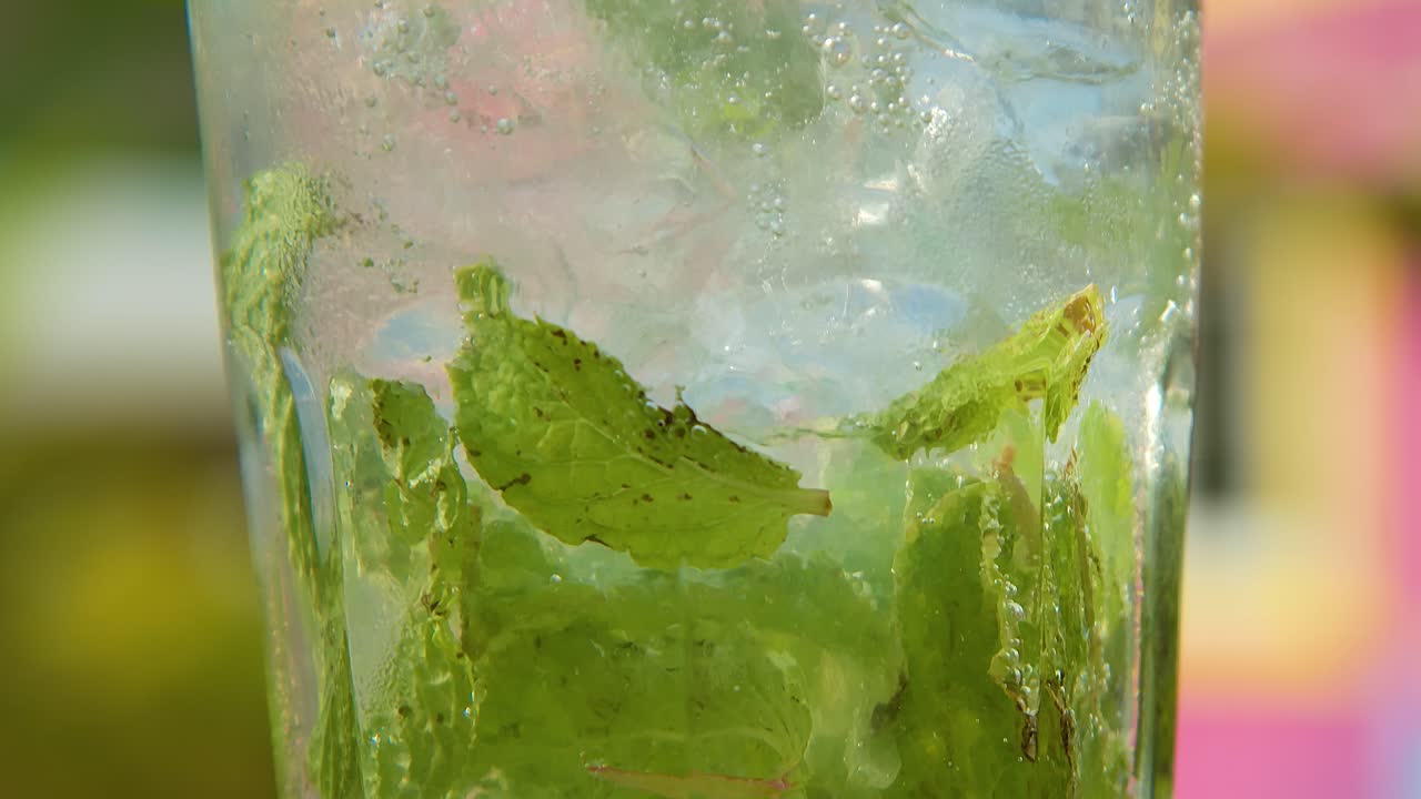 높은 유리 모지토 음료의 기울기, 분홍색 배경으로 떠다니는 거품