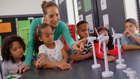 Front-view-of-Caucasian-female-teacher-teaching-schoolkids-about-windmill-in-the-classroom-4k