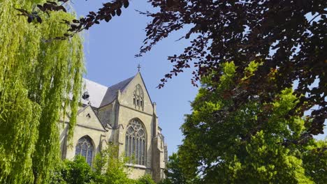 Statische-Aufnahme-Der-Niederländischen-Abbés-Kirche-In-Thorn-Mit-Blick-Auf-Die-Architektur,-Während-Die-Bäume-An-Einem-Sonnigen,-Wolkenlosen-Tag-Im-Wind-Wehen