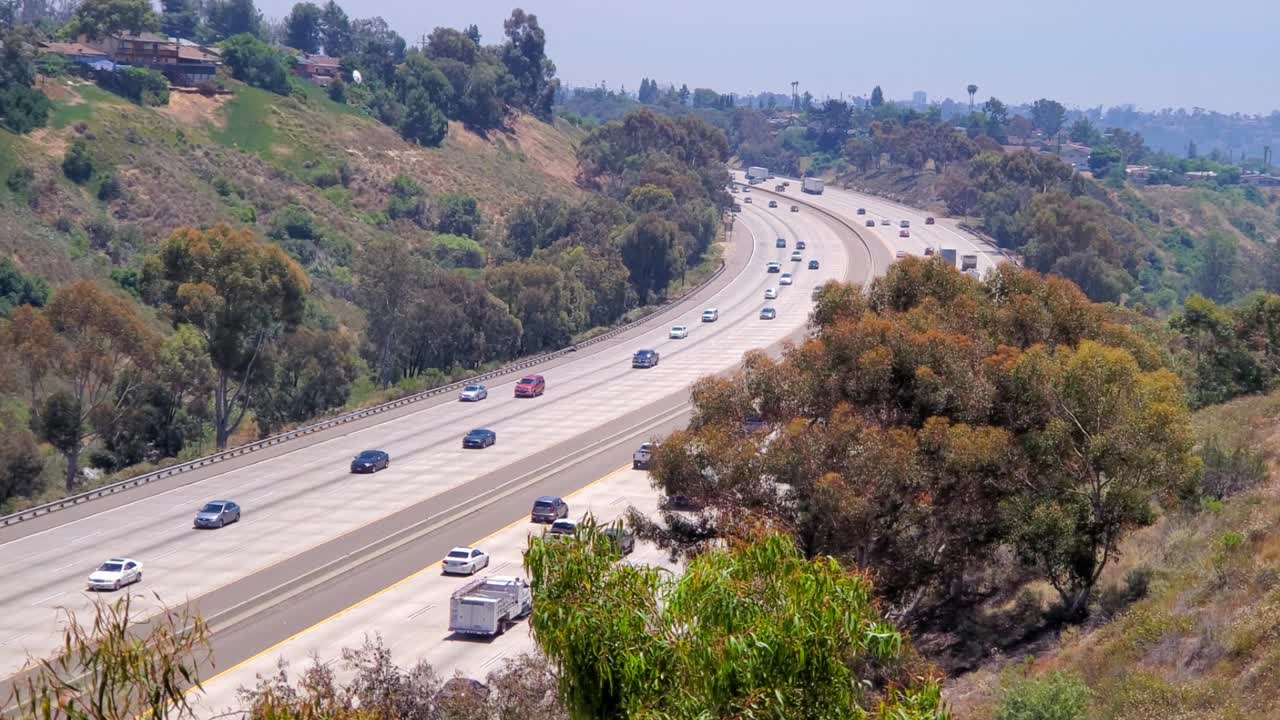 Freeway i805 in California SoCal area with trucks cars and semis in moderate traffic, Locked high angle shot