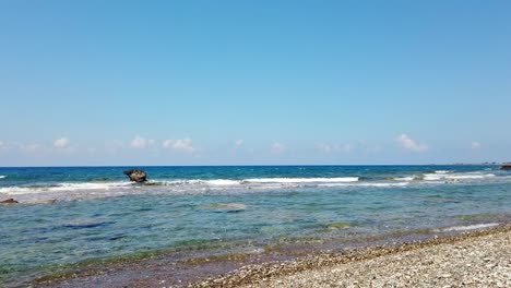 waves crash against rocks in the sea and along the shore at mandria beach, cyprus. a raw, beautiful moment showing nature’s rhythm—ideal for coastal, travel, or relaxation themes.